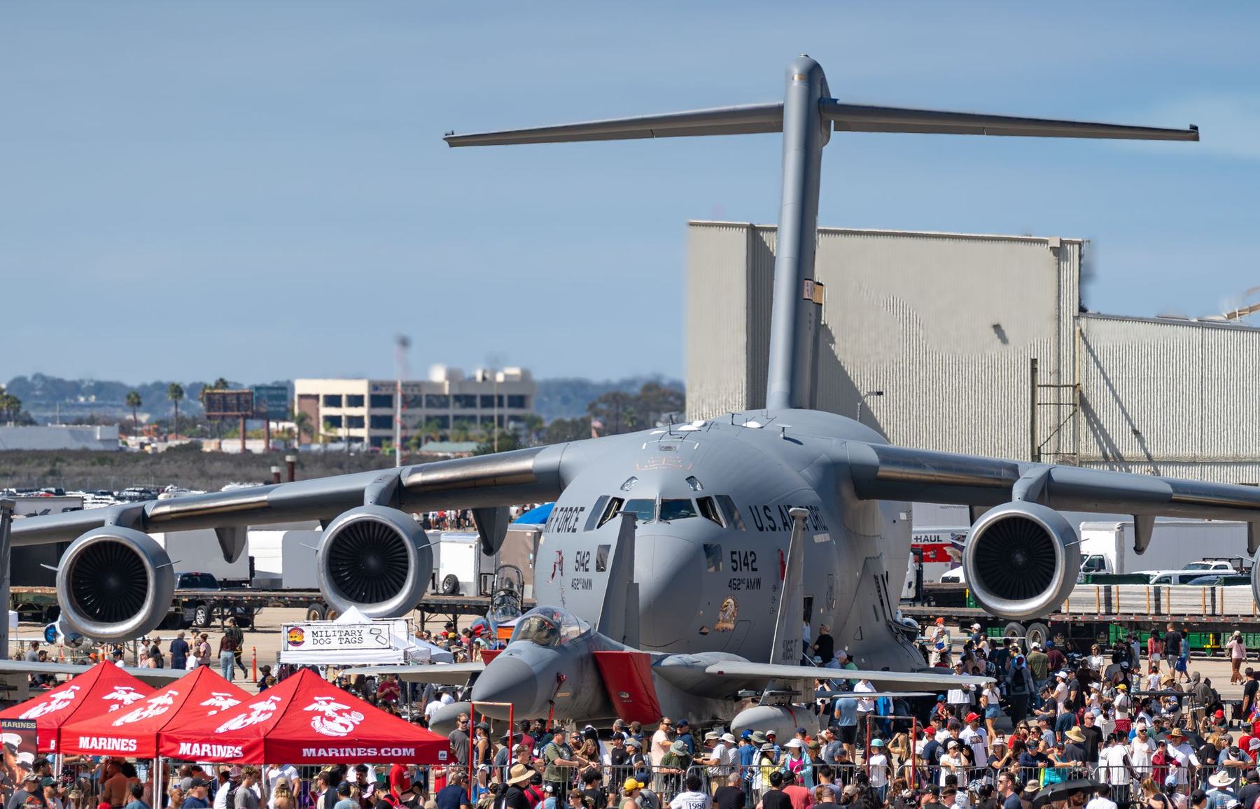 A C-17 cargo jet on display at an air show, surrounded by a large crowd