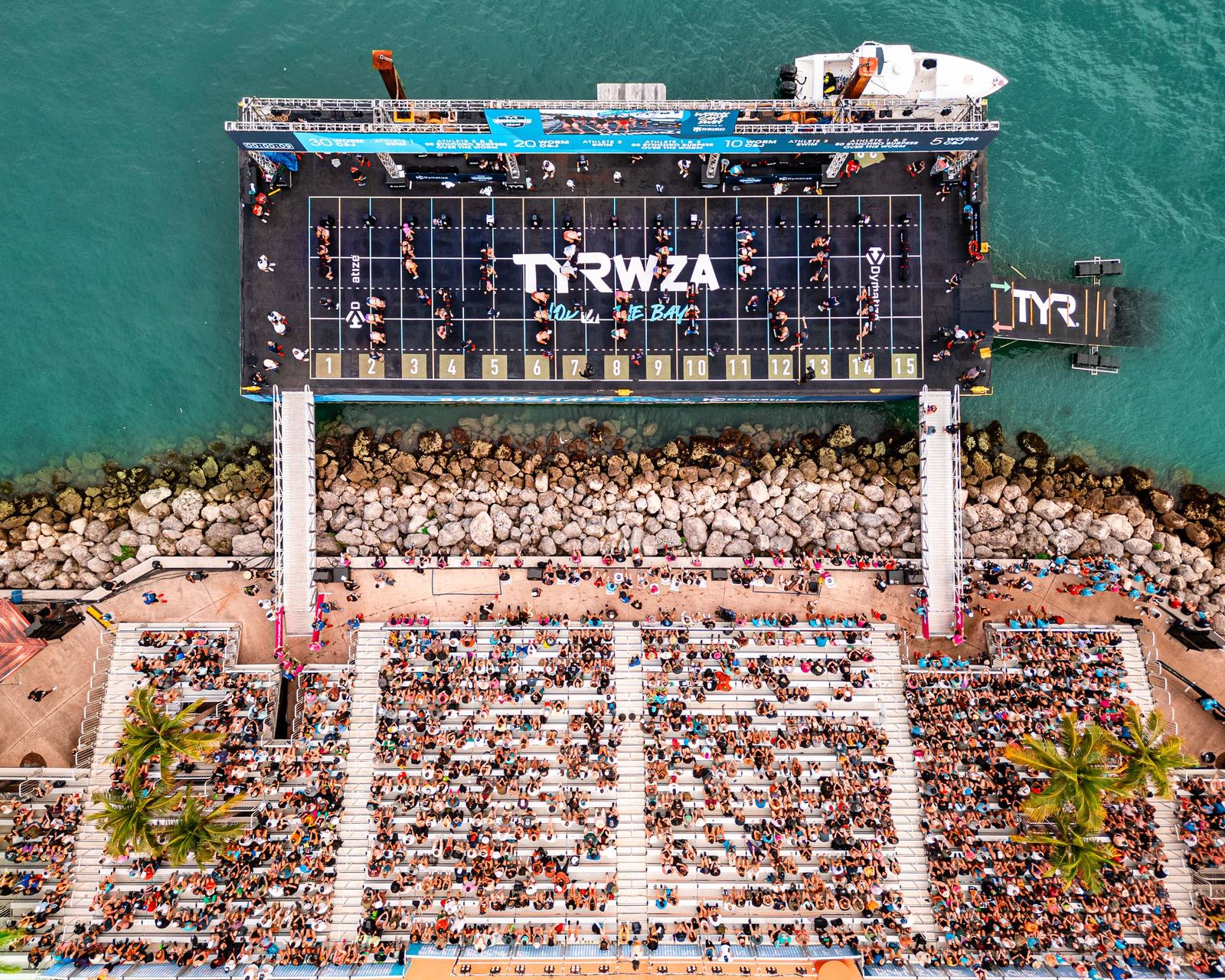 Top-down view of the barge stage facing a packed waterfront lawn