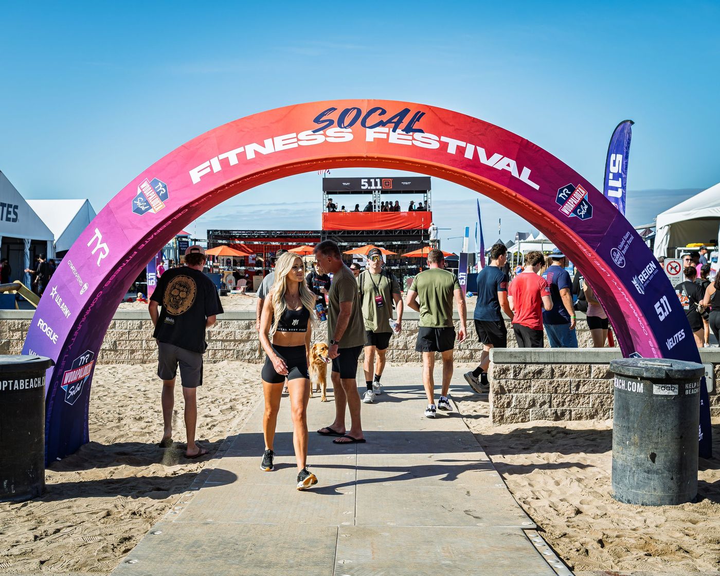 Athletes walking under the festival entrance arch on the sand